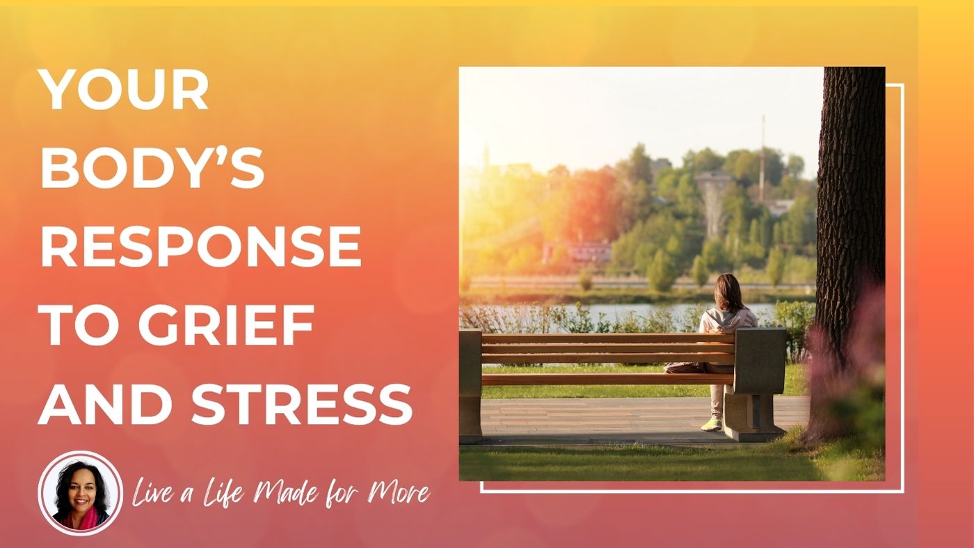 Woman sitting quietly outdoors, hand resting on chest, reflecting on the mind-body connection to grief and stress